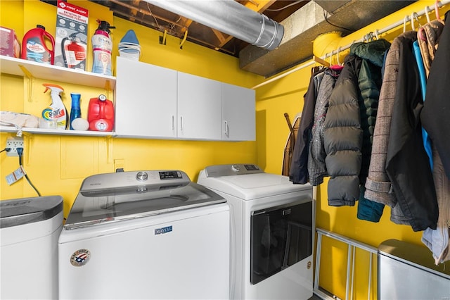 laundry area with independent washer and dryer and cabinets