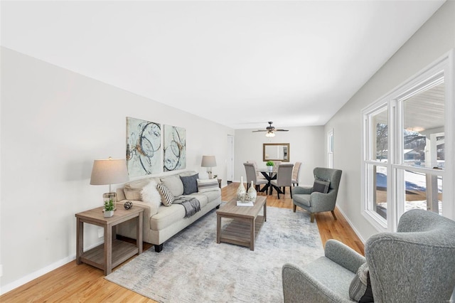 living room featuring a wealth of natural light, light hardwood / wood-style flooring, and ceiling fan