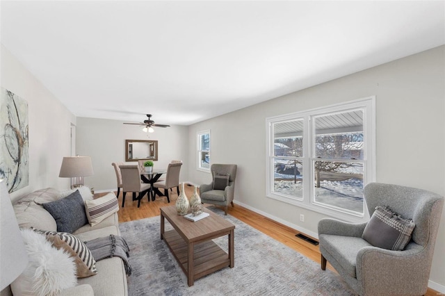 living room featuring ceiling fan and light hardwood / wood-style floors