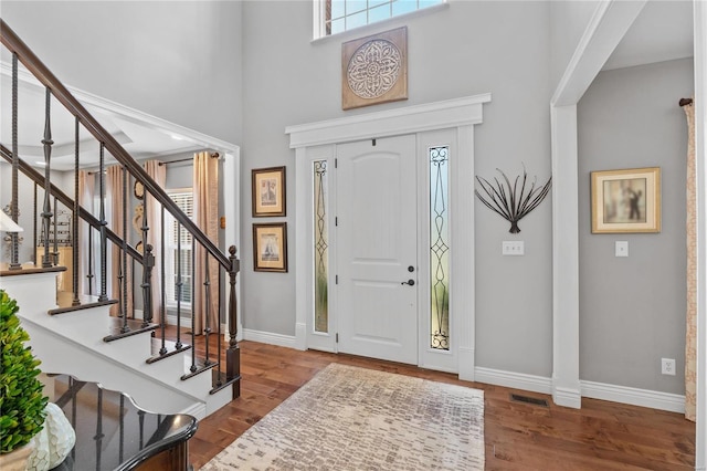 entryway with a towering ceiling and hardwood / wood-style floors