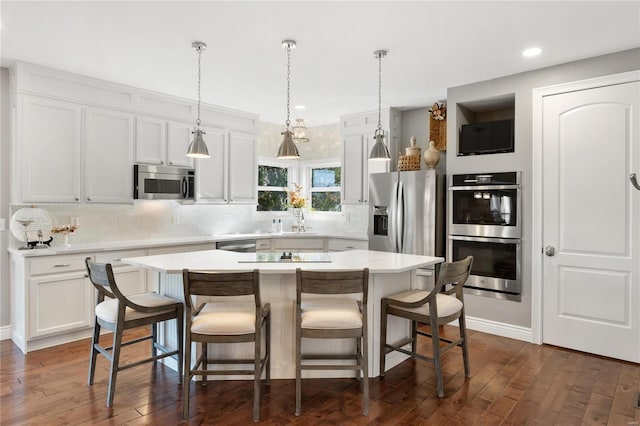 kitchen with tasteful backsplash, dark hardwood / wood-style flooring, a kitchen island, stainless steel appliances, and white cabinets