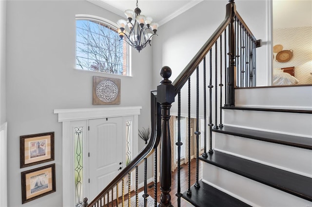 entrance foyer featuring a notable chandelier, ornamental molding, and hardwood / wood-style flooring