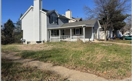 exterior space featuring covered porch and a front yard