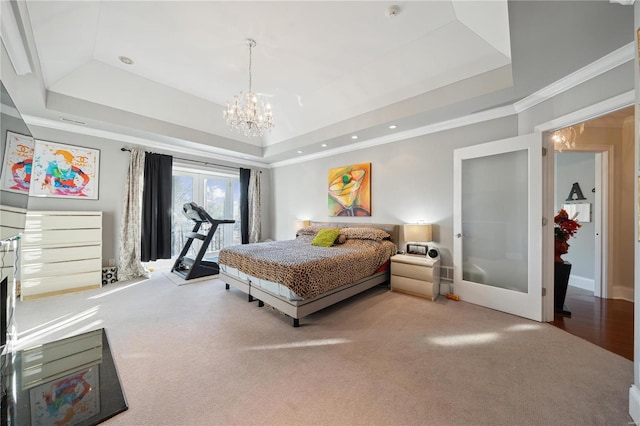 bedroom featuring french doors, a raised ceiling, carpet flooring, ornamental molding, and a notable chandelier