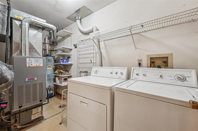 clothes washing area featuring heating unit, washing machine and dryer, and water heater