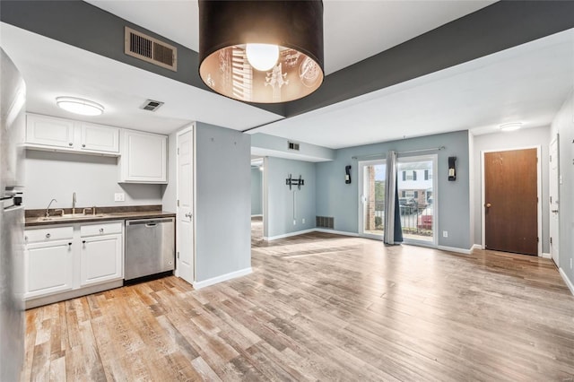 kitchen featuring white cabinetry, stainless steel dishwasher, light hardwood / wood-style floors, and sink