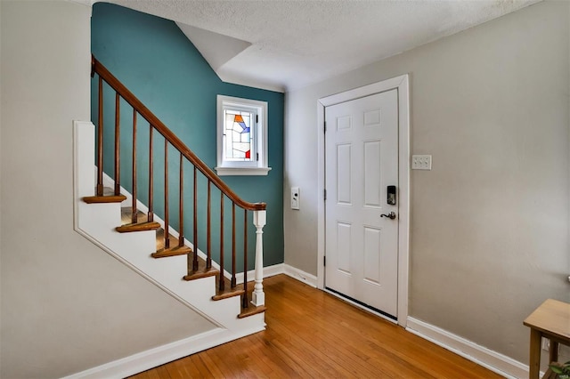 entryway with hardwood / wood-style floors and a textured ceiling