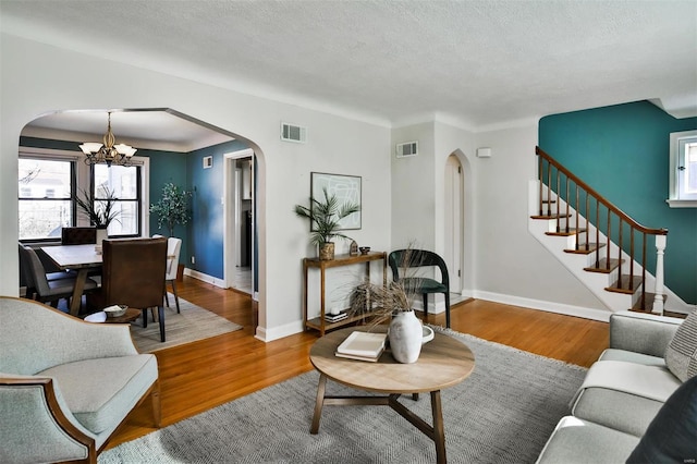 living room featuring hardwood / wood-style flooring, a textured ceiling, and a chandelier