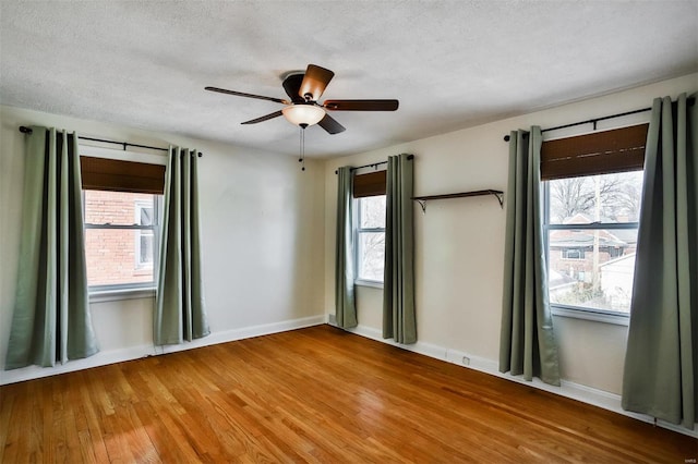 empty room featuring ceiling fan, wood-type flooring, and a textured ceiling