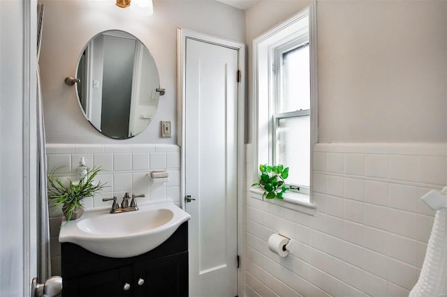 bathroom with vanity and tile walls