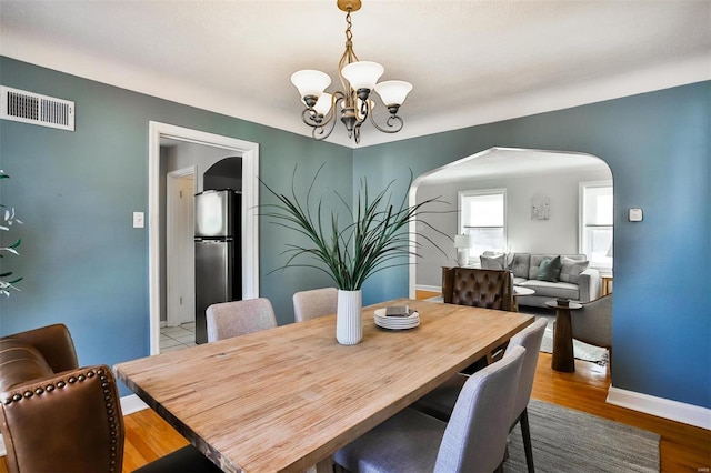 dining area with a notable chandelier and light wood-type flooring