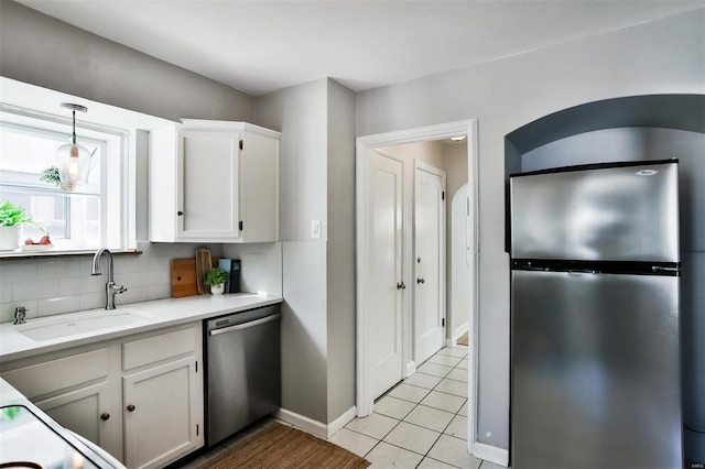 kitchen with sink, tasteful backsplash, hanging light fixtures, stainless steel appliances, and white cabinets