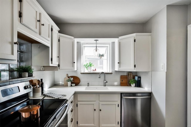 kitchen with sink, white cabinetry, decorative light fixtures, stainless steel appliances, and decorative backsplash