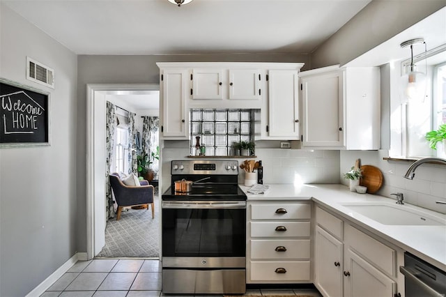 kitchen featuring stainless steel appliances, white cabinetry, sink, and light tile patterned floors