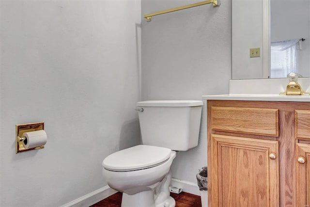 bathroom with hardwood / wood-style flooring, vanity, and toilet