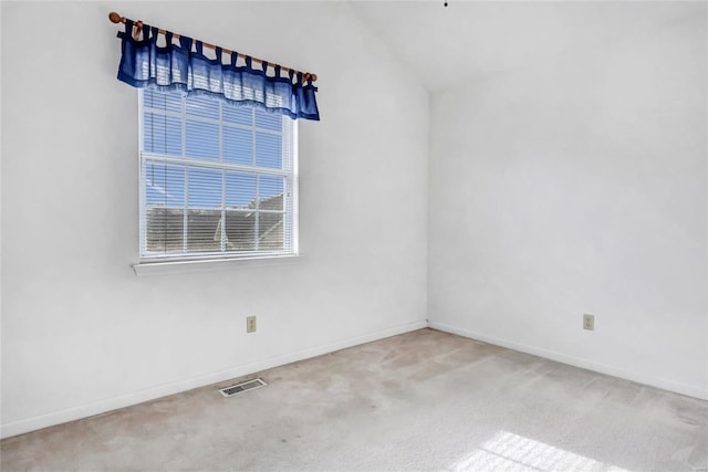 carpeted empty room featuring lofted ceiling