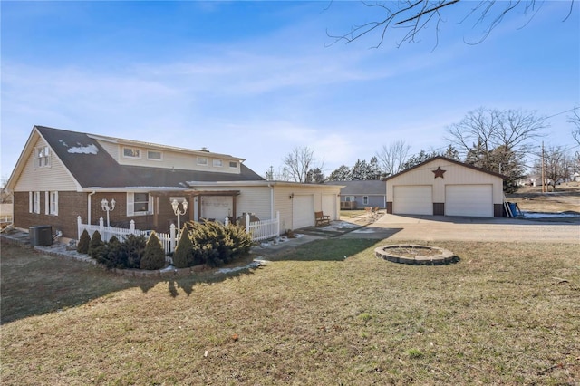 exterior space featuring a garage, a lawn, and central AC