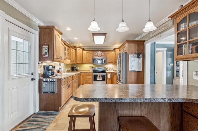 kitchen with a breakfast bar, hanging light fixtures, ornamental molding, and stainless steel appliances