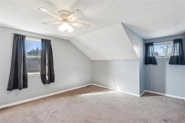 additional living space featuring light carpet, ceiling fan, and lofted ceiling