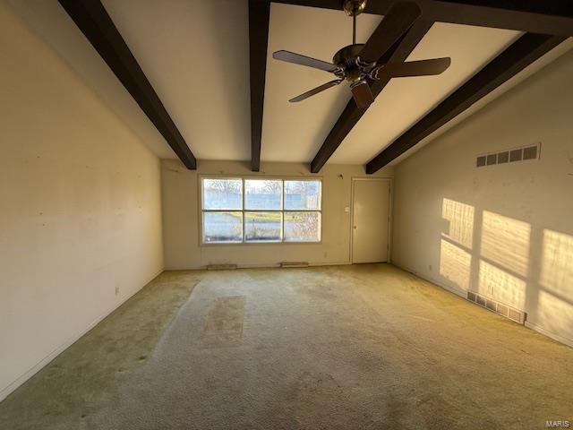 spare room with ceiling fan, light colored carpet, and lofted ceiling with beams