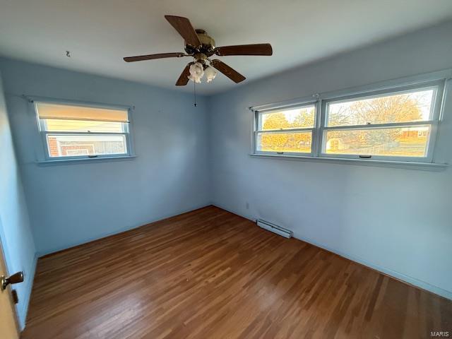 unfurnished room featuring wood-type flooring, plenty of natural light, and ceiling fan