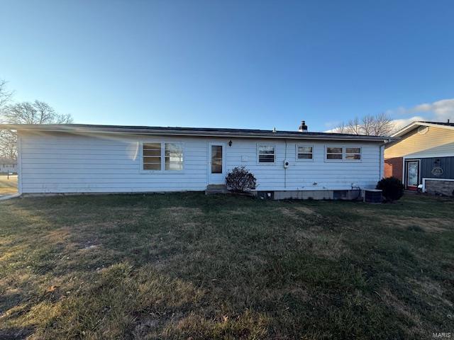 rear view of property featuring a yard