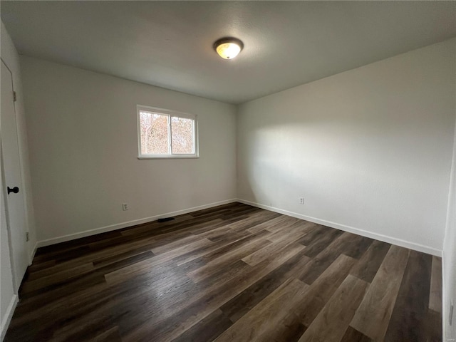 spare room with dark hardwood / wood-style flooring