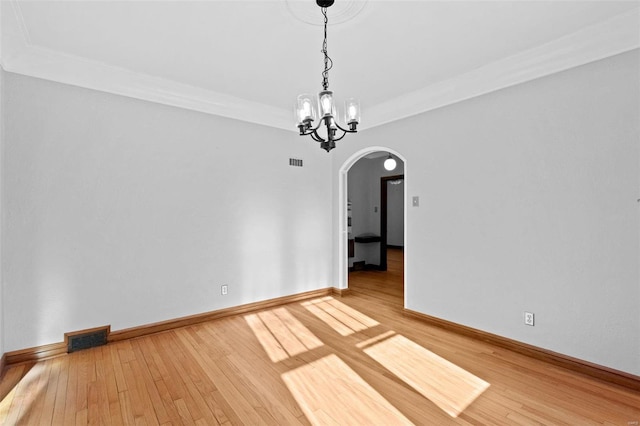 unfurnished room featuring a notable chandelier and hardwood / wood-style flooring