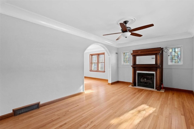 unfurnished living room with crown molding, ceiling fan, and light wood-type flooring