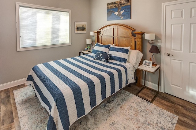 bedroom with dark hardwood / wood-style floors