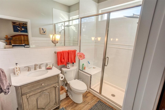 bathroom with hardwood / wood-style floors, vanity, toilet, walk in shower, and tasteful backsplash