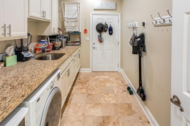 kitchen featuring light stone countertops, sink, and white cabinets