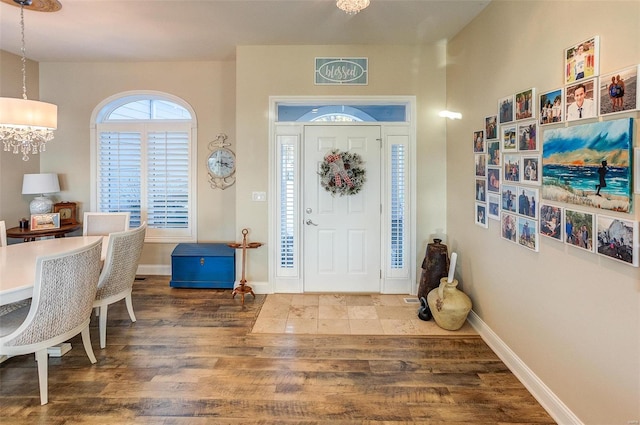 foyer entrance with dark wood-type flooring and an inviting chandelier