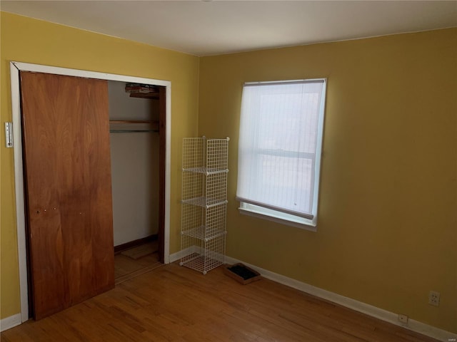 unfurnished bedroom with a closet and hardwood / wood-style floors