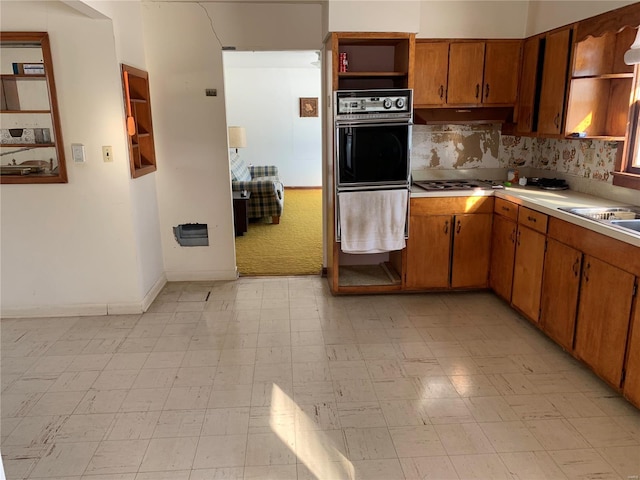 kitchen with double oven, white gas stovetop, and sink