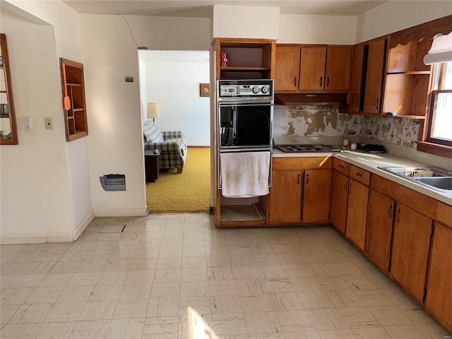 kitchen with sink, black double oven, and gas stovetop