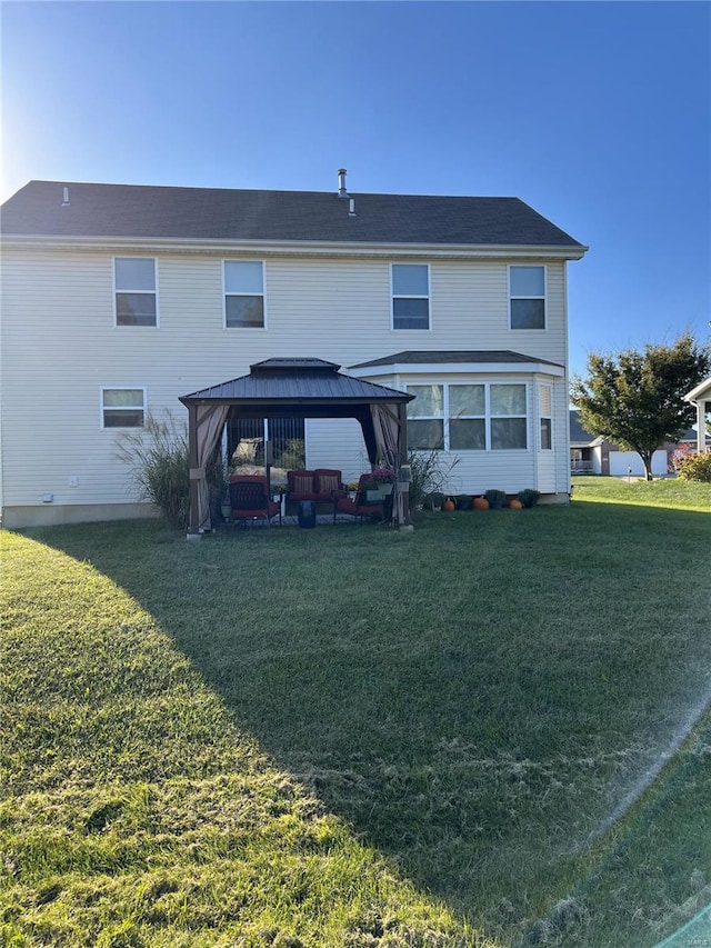 rear view of house with a gazebo and a lawn