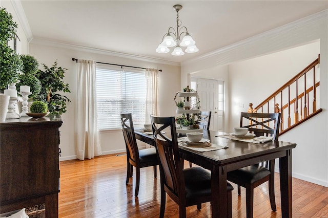 dining room featuring ornamental molding, light hardwood / wood-style floors, and a notable chandelier