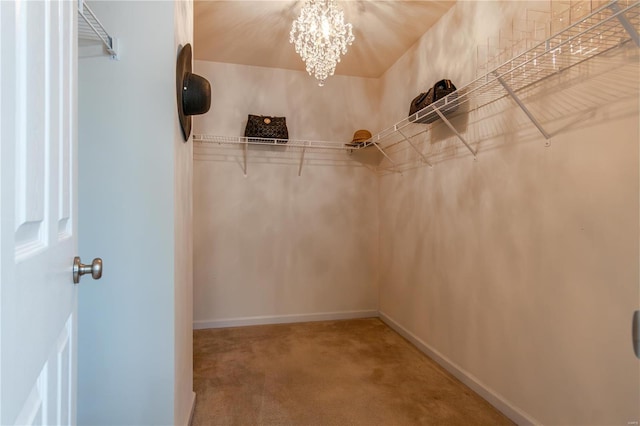 walk in closet with carpet flooring and a notable chandelier