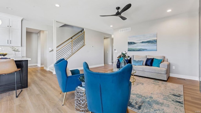 living room featuring light wood-type flooring and ceiling fan