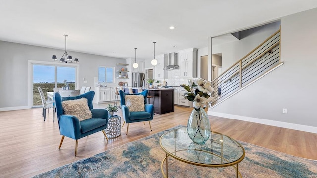 living room with an inviting chandelier and light hardwood / wood-style flooring