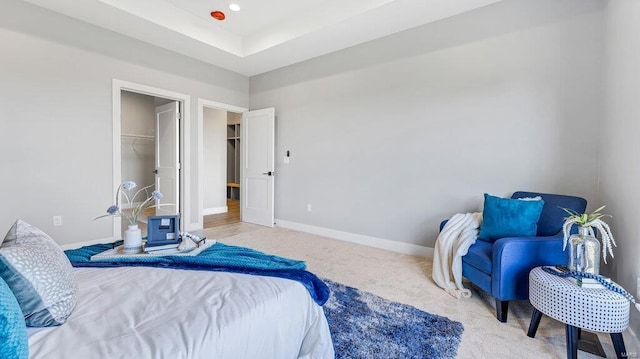 carpeted bedroom with a walk in closet and a closet