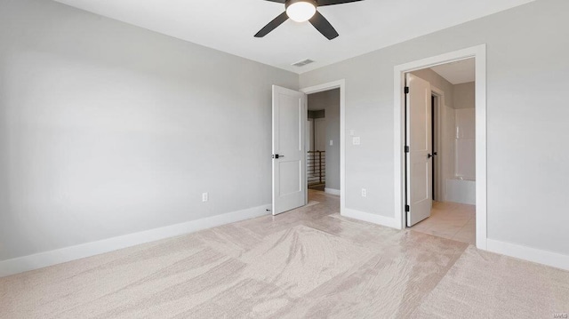 unfurnished bedroom featuring ceiling fan, light carpet, and connected bathroom