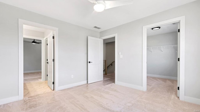 unfurnished bedroom featuring ceiling fan, light colored carpet, and a closet