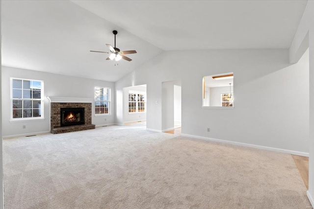 unfurnished living room with light carpet, a brick fireplace, lofted ceiling, and ceiling fan