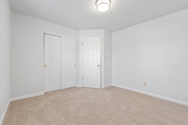 unfurnished bedroom with light carpet and a closet