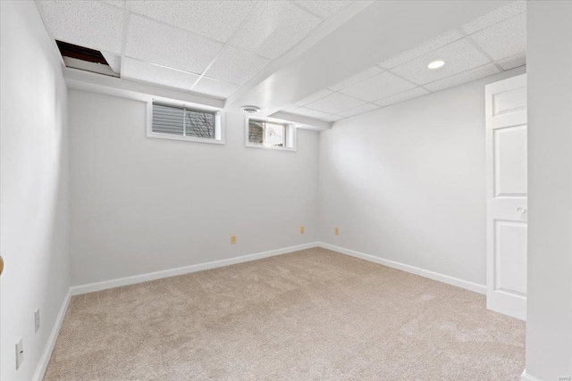 basement with light colored carpet and a drop ceiling