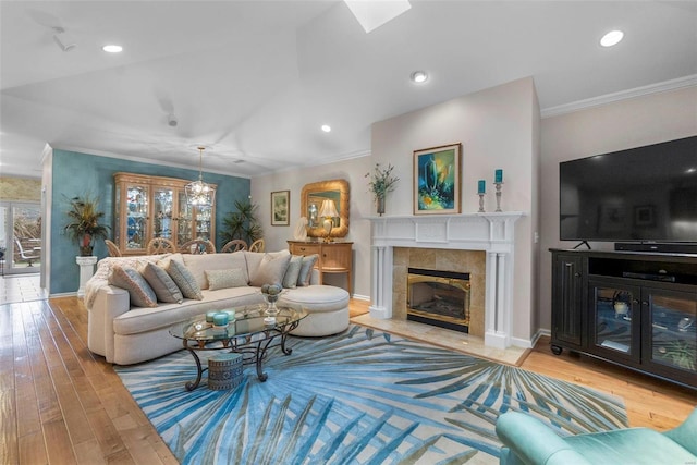 living room with light wood-type flooring, a fireplace, and ornamental molding