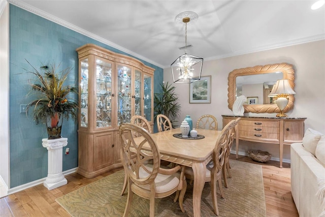 dining area featuring light hardwood / wood-style flooring, a notable chandelier, and ornamental molding