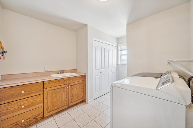 washroom featuring light tile patterned floors, sink, separate washer and dryer, and cabinets